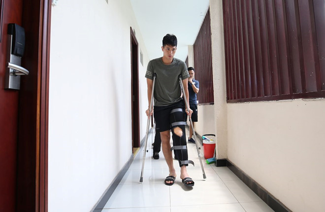 Đình Trọng phải chống nạng khi rời khách sạn để di chuyển về quê nhà ở Gia Lâm NAM ANH