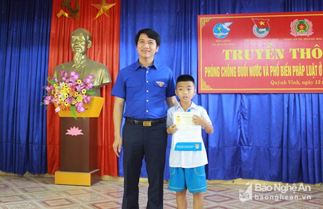 Bí thư Trung ương Đoàn Nguyễn Ngọc Lương trao Huy hiệu "Tuổi trẻ dũng cảm" cho em Nguyễn Quang Dũng. Ảnh: Phương Thúy